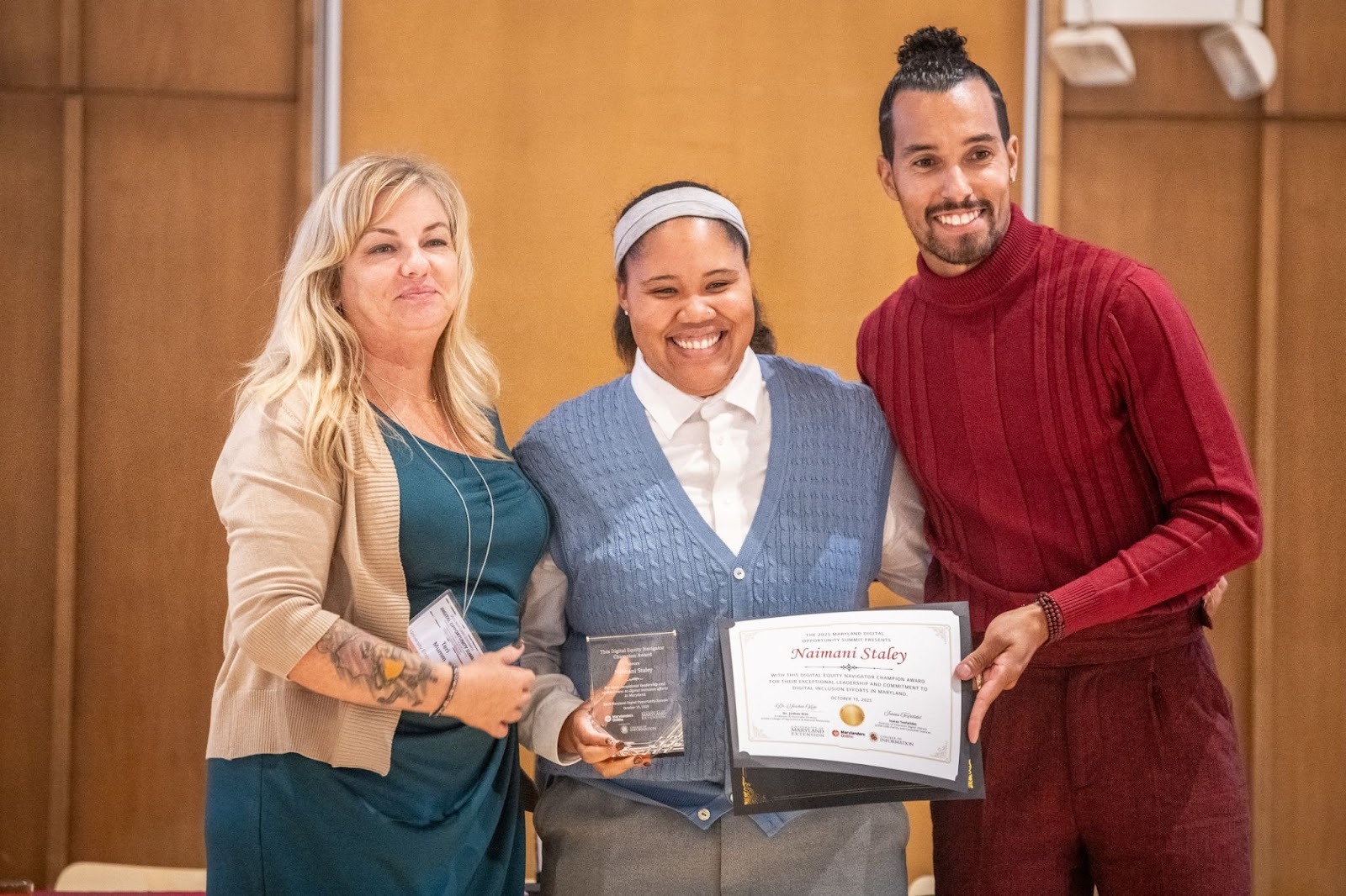 Pictured: Naimani Staley, Tech Extension Educator, stands to accept the Navigator Champion Award from  Teri Mumm, Digital Navigation Program Manager, UME Marylanders Online (left) and Ronnie Hammond, Director of the Maryland Office of Statewide Broadband (right).