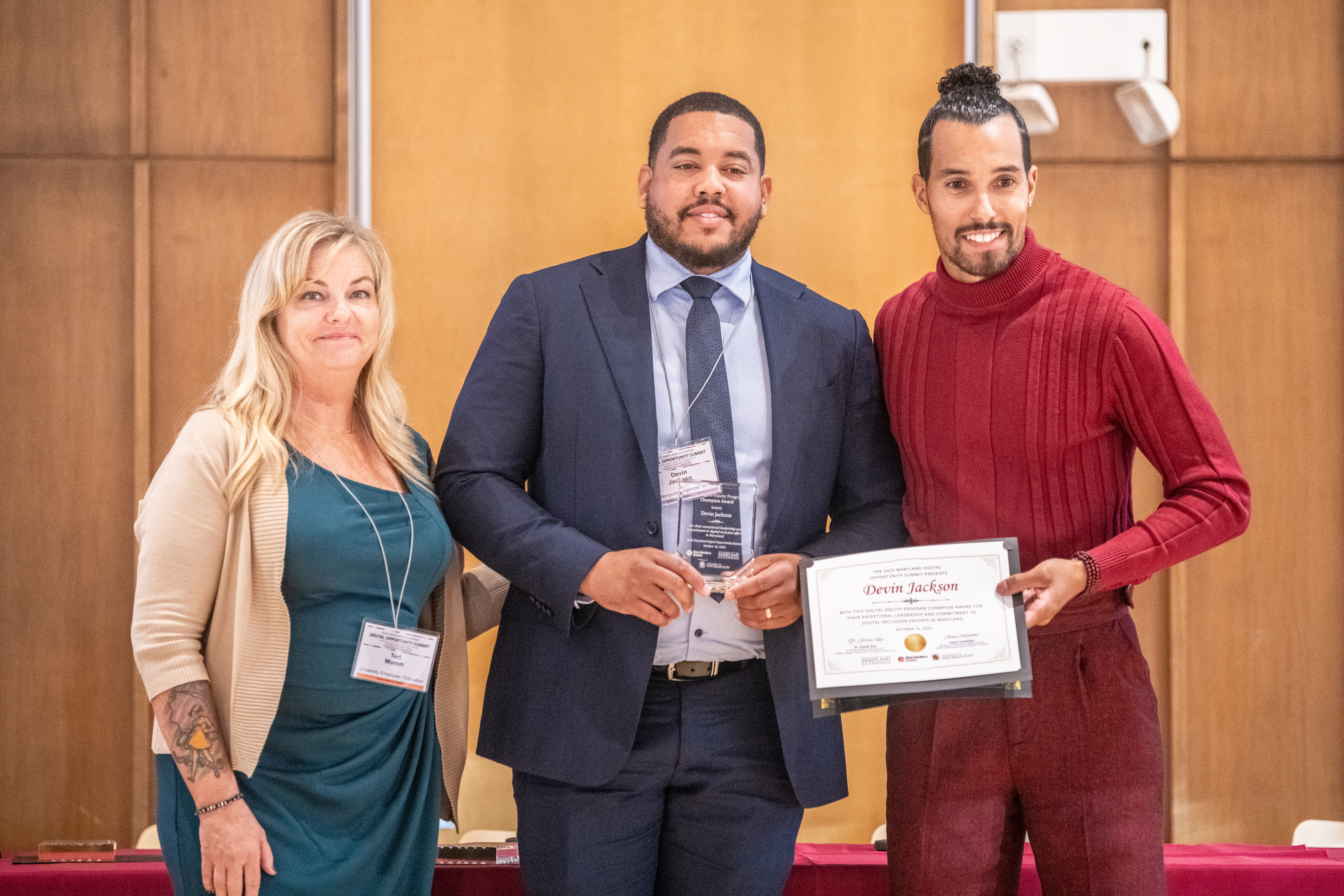 Devin Jackson, CEO and President of A Prosperous Tomorrow, accepts the Program Champion Award from Teri Mumm and Ronnie Hammond.